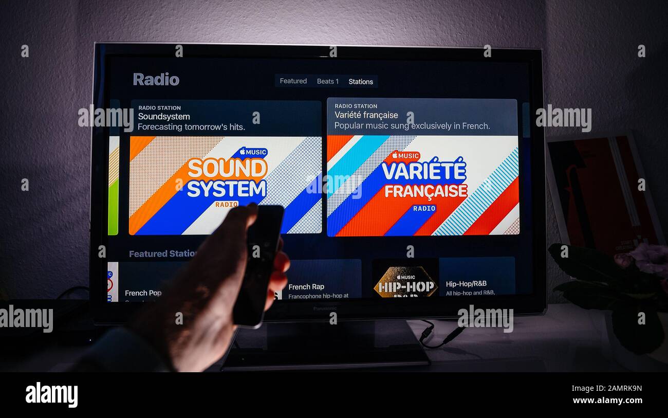 ned reagere Deltage Paris, France - Circa 2019: Man with remote on Apple TV menu on Panasonic  Plasma tv living room with top 100 list charts Charting now and Radio  station French Variety hits playlist