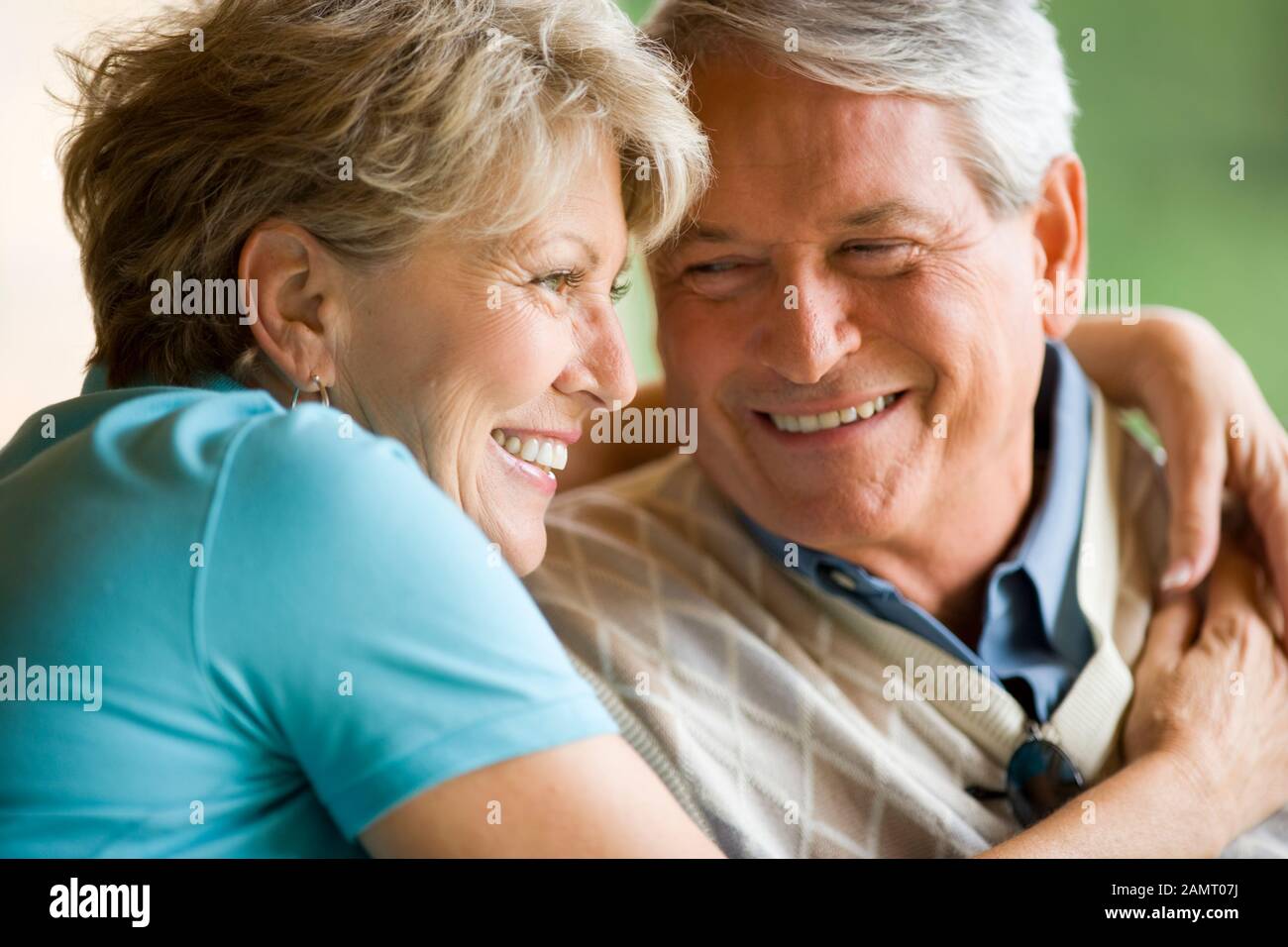 Older couple smiling with arms around each other Stock Photo - Alamy