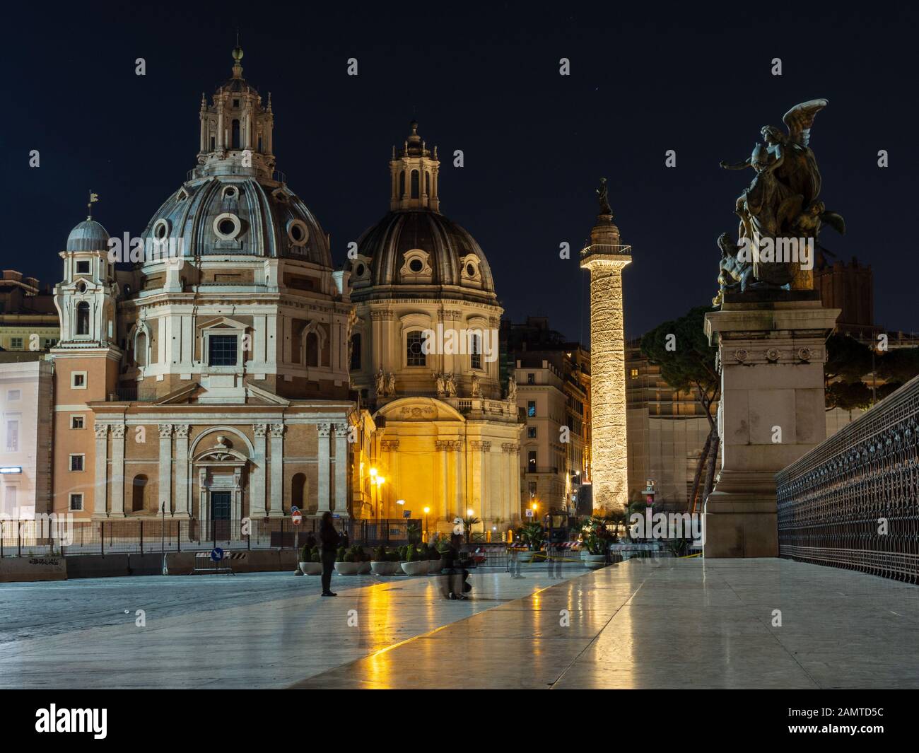 Rome, Italy - March 25, 2018: Tourists stop for photos of the ancient and Renaissance architecture of Piazza Venezia in Rome at night. Stock Photo