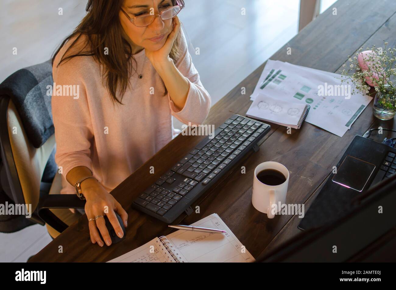 Woman sitting at her desk working Stock Photo
