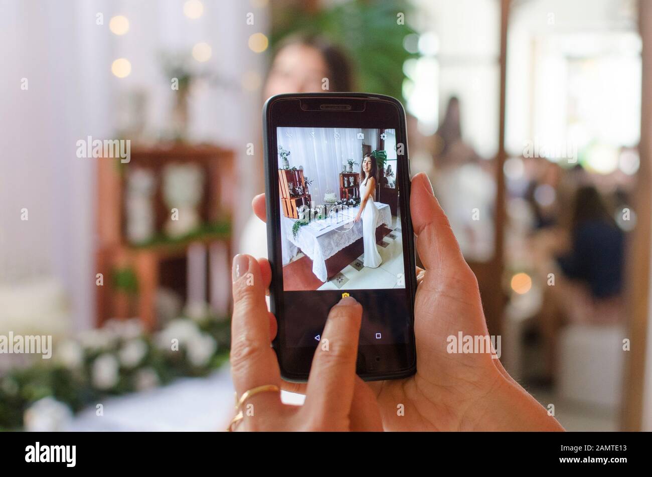 Woman photographing her daughter standing in front of a festive birthday table setting Stock Photo