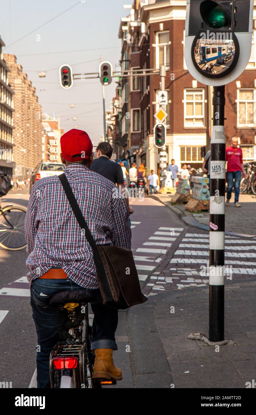 Amsterdam, Netherlands - October 2, 2011: A cyclist waits at a traffic signal in the centre of the city of Amsterdam. Stock Photo