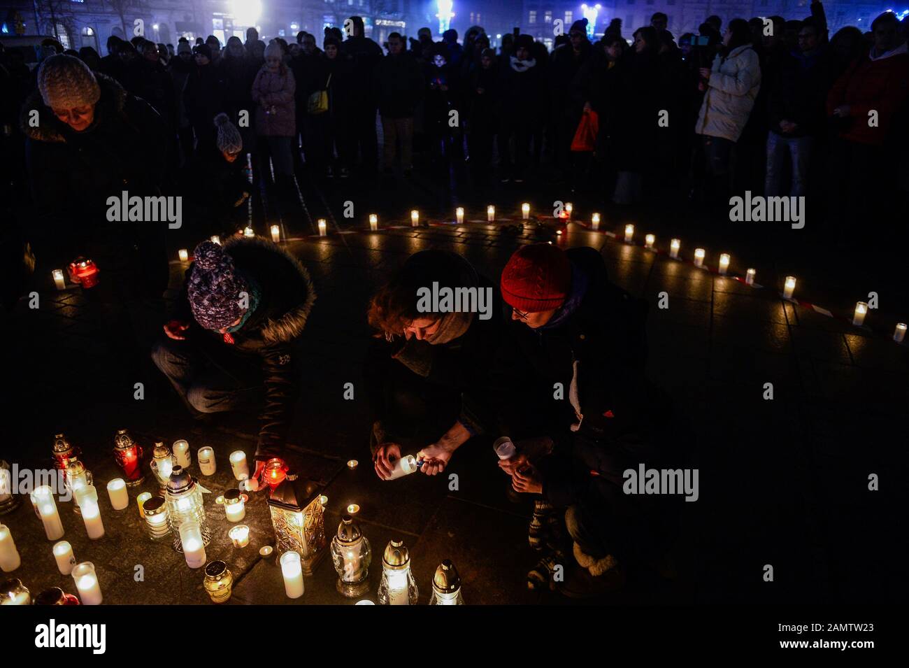 Krakow, Poland. 14th Jan, 2020. People place candles to a symbolic