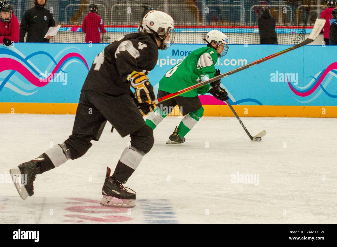 Lausanne, Switzerland. 13th Jan, 2020. Yau Yam (green) and Kerem Alsan (black) in action during the men's mixed NOC 3-on-3 ice hockey preliminary round (game 27; green v. black), during Day 4 of the Lausanne 2020 Winter Youth Olympic Games, at Lausanne Skating Arena. Credit: SOPA Images Limited/Alamy Live News Stock Photo