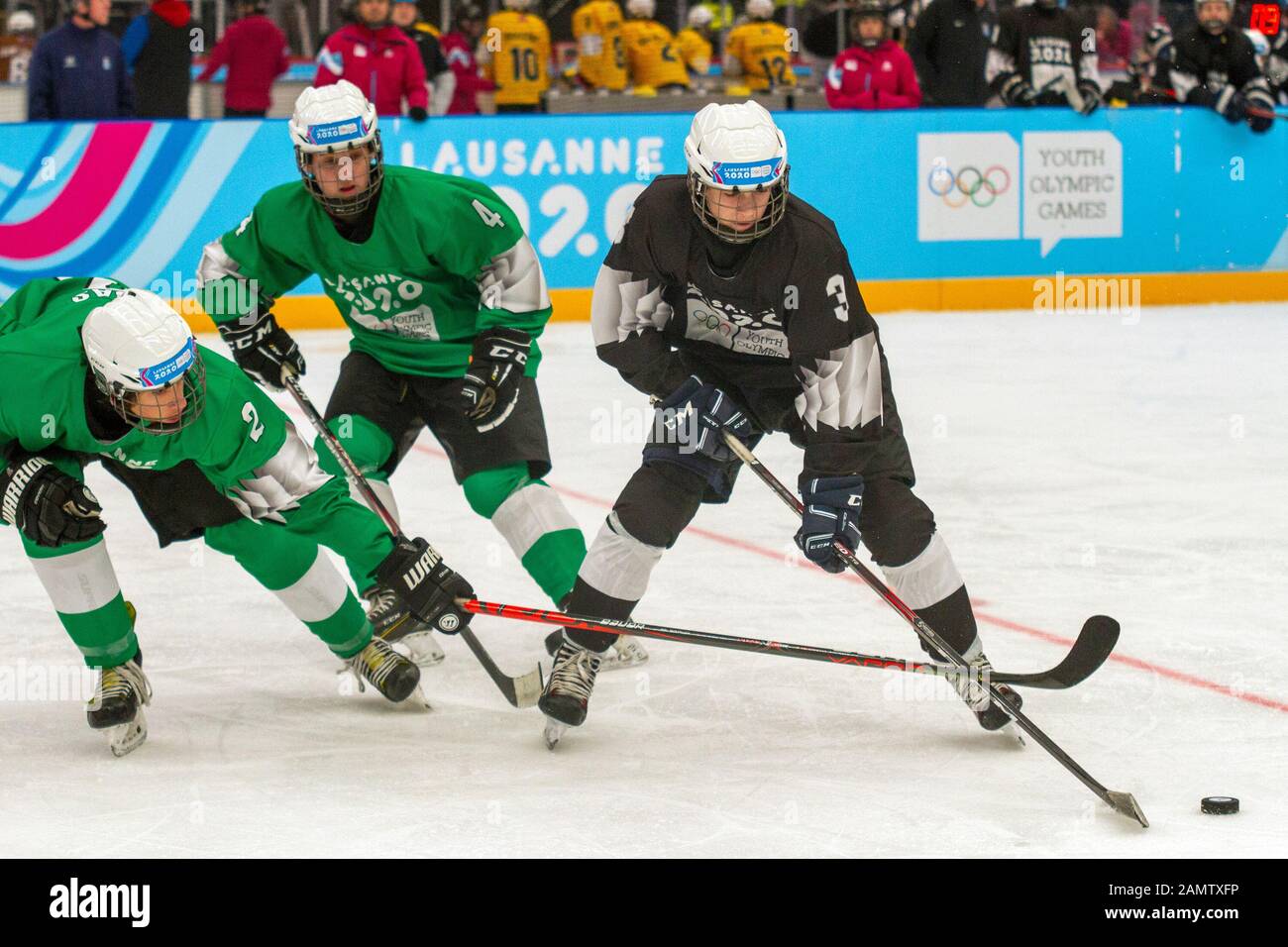 Lausanne, Switzerland. 13th Jan, 2020. Lukas Floriantschitz (black), Nicolas Elgas (green) and Nathan Nicoud (green) in action during the men's mixed NOC 3-on-3 ice hockey preliminary round (game 27; green v. black), during Day 4 of the Lausanne 2020 Winter Youth Olympic Games, at Lausanne Skating Arena. Credit: SOPA Images Limited/Alamy Live News Stock Photo