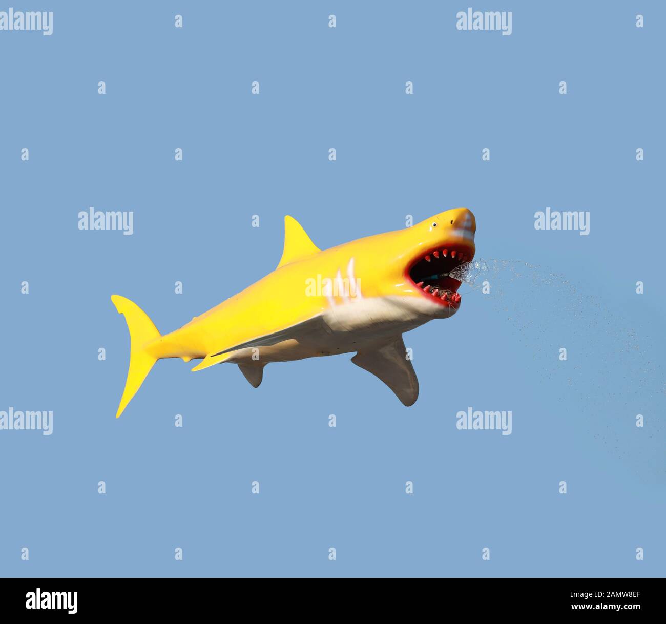 statue of a shark spewing water isolated on color background. Stock Photo