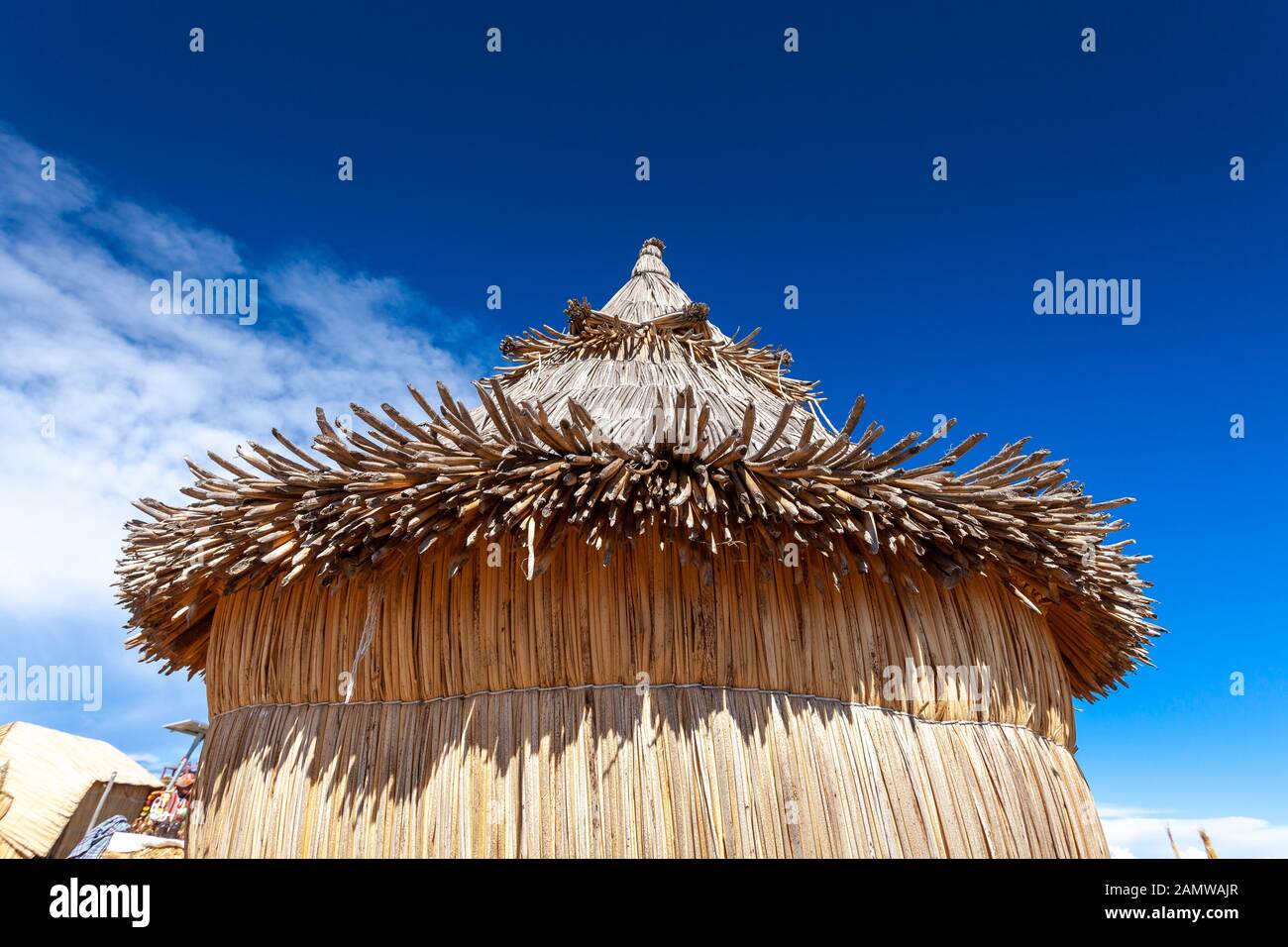 Traditional reed houses on floating Uros islands, at a distance, clouds