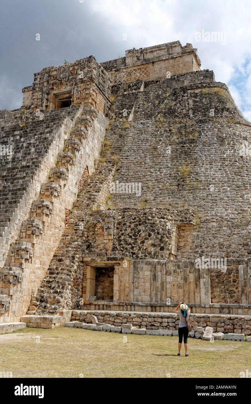 Young woman tourist photographing the Pyramid of the Magician at the Mayan ruins of Uxmal, Yucatan, Mexico Stock Photo