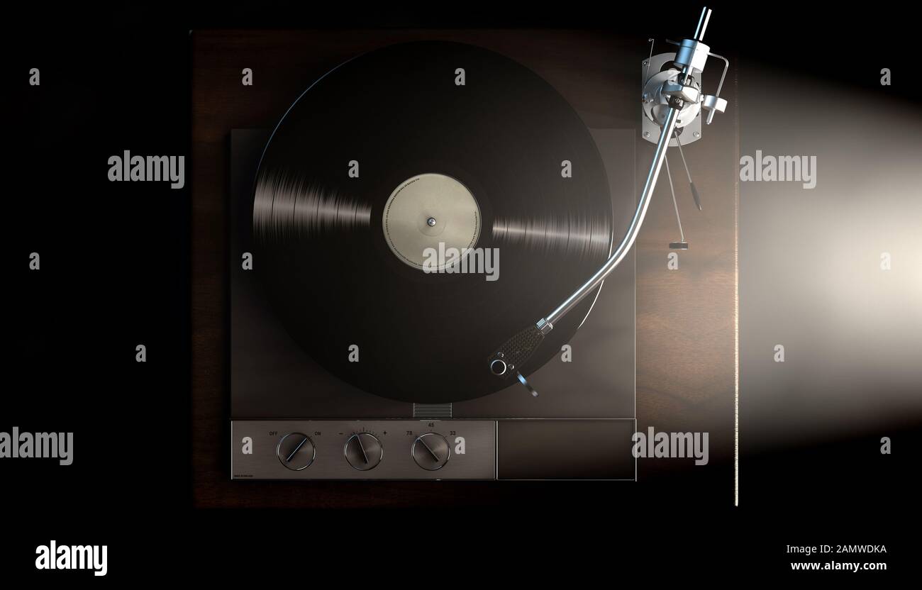 A vintage unbranded turntable playing a vinyl record on a moody backlit ...