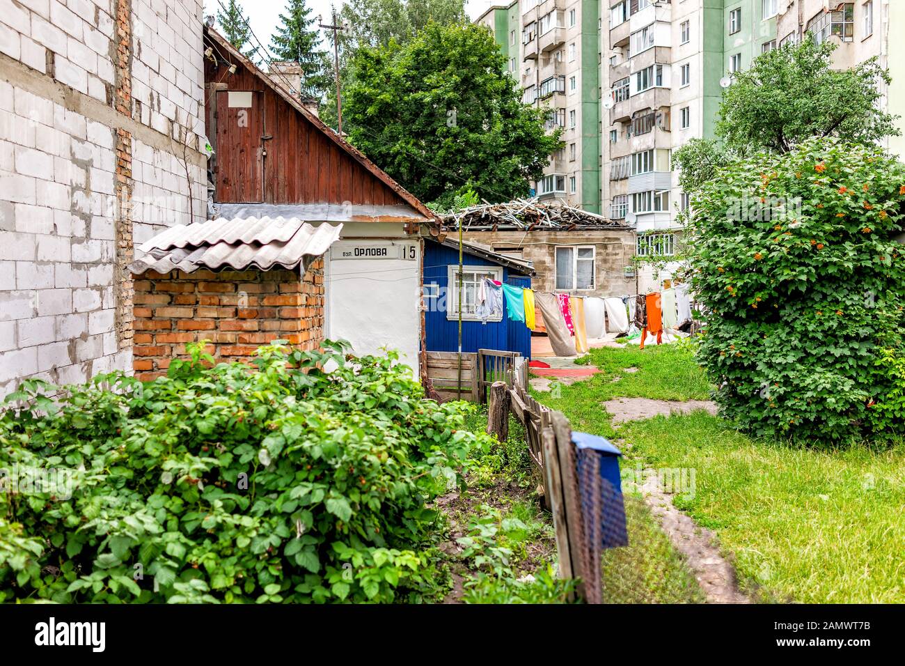 Rivne, Ukraine - July 3, 2018: Rural country house home farm dacha in Eastern Europe with wall and berries in garden with address sign and clothes dry Stock Photo