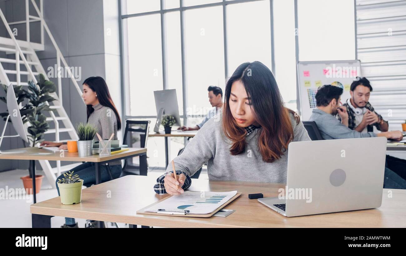 Group of diversity creative designer working at modern office building.casual office lifestyle with technology.woman designer writing plan on paper Stock Photo