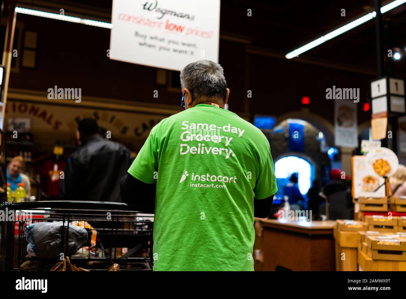 Fairfax, USA - December 5, 2019: Wegmans grocery store interior with Instacart man worker and sign on shirt for same-day delivery Stock Photo