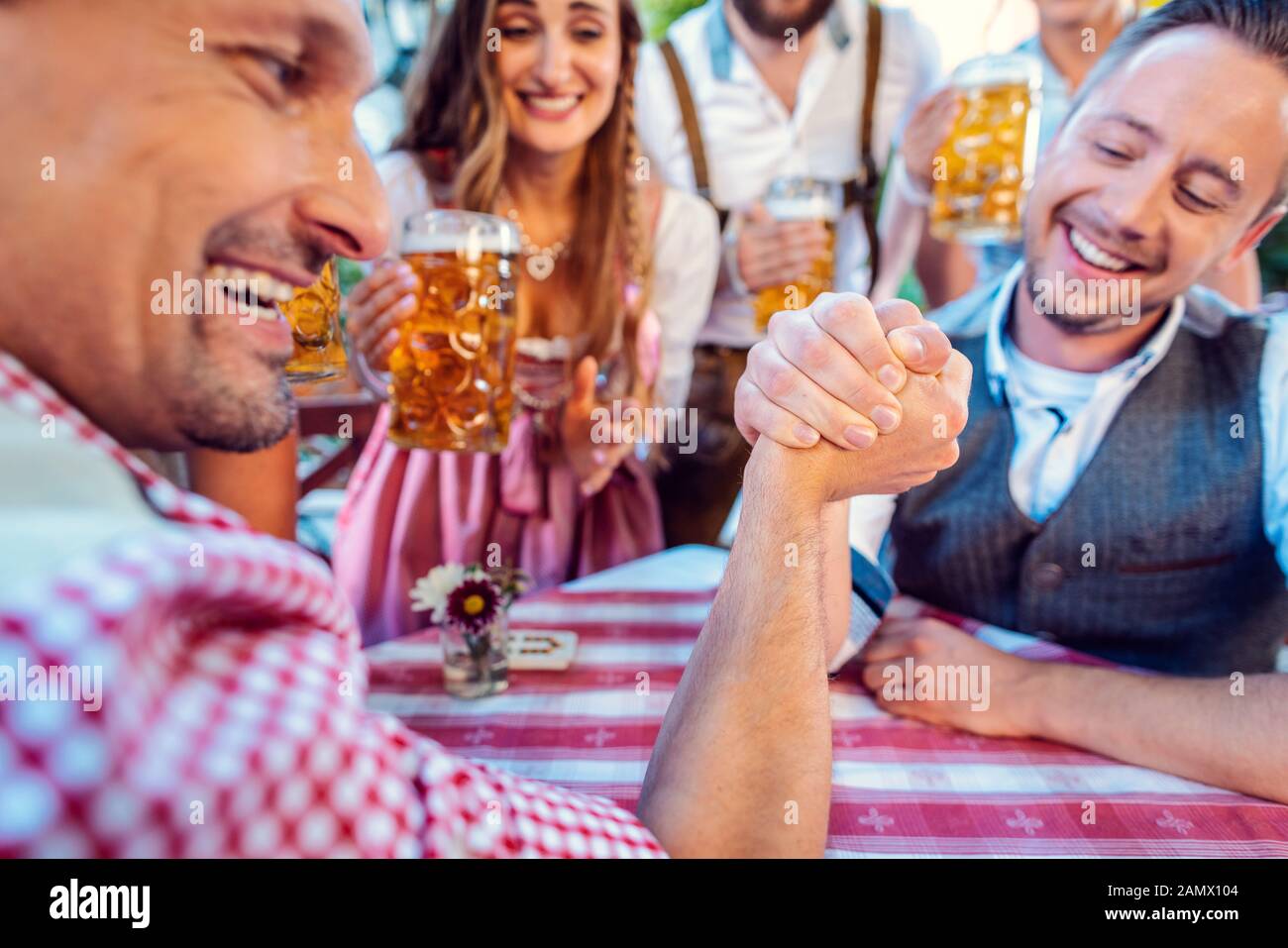 Bavarian friends practicing the high art of arm wrestling Stock Photo