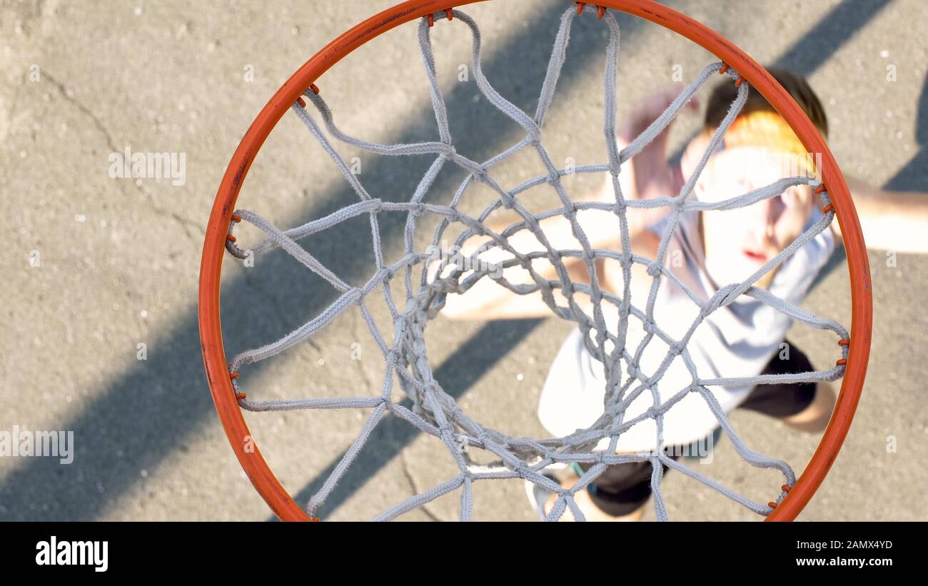 Male athlete shooting ball through basket, professional basketball