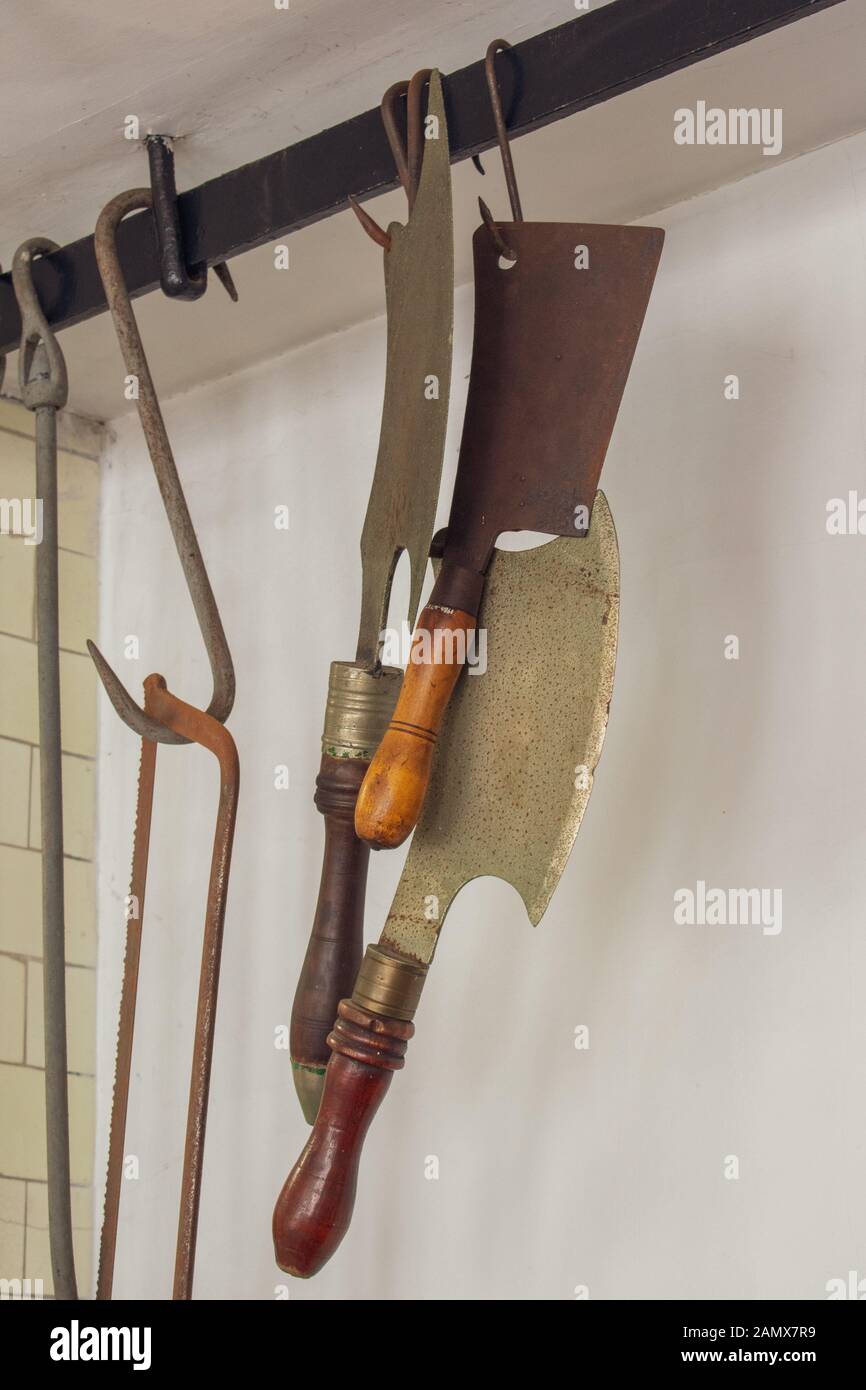 Old butchers cleavers and tools hanging from hooks Stock Photo Alamy