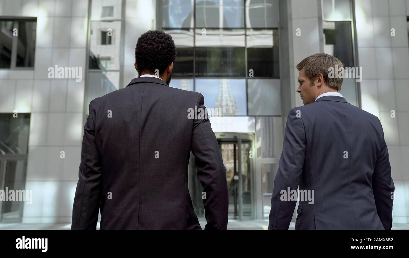 Office workers in suits going to work in modern business center, white collars Stock Photo