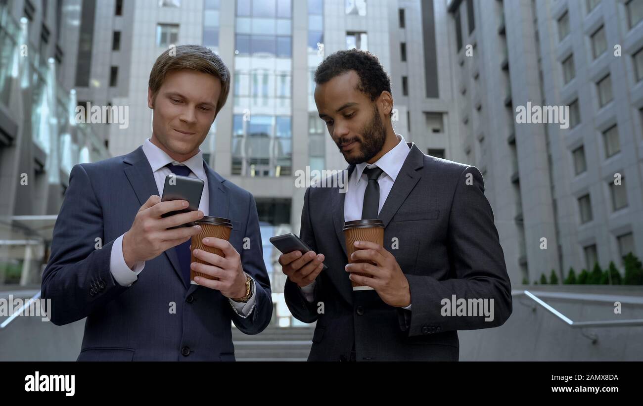 Office workers drinking coffee on break, surfing internet, social network apps Stock Photo