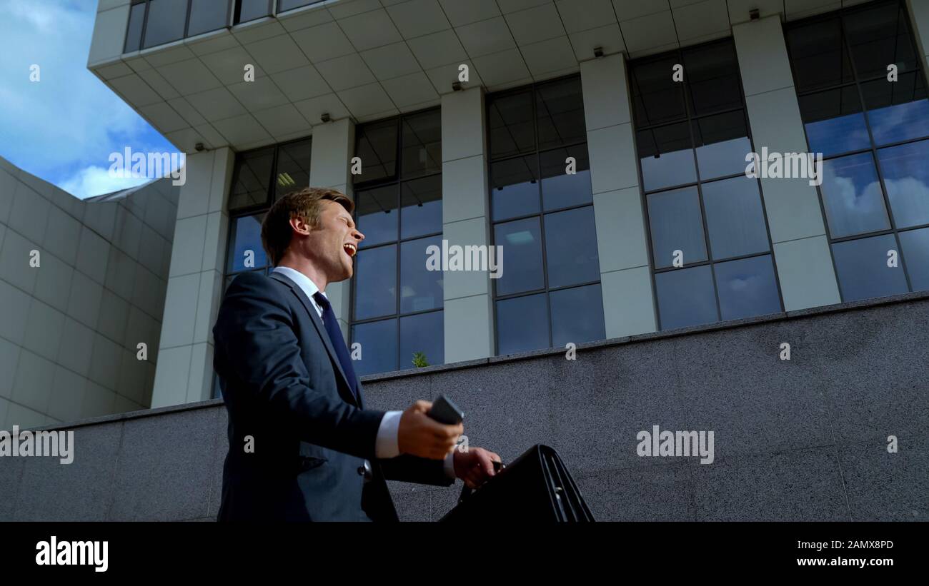 Young male in business suit happy with news success in financial operation Stock Photo