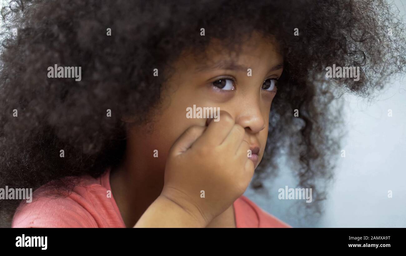 Depressed mulatto girl suffering Down syndrome sitting at table, healthcare Stock Photo