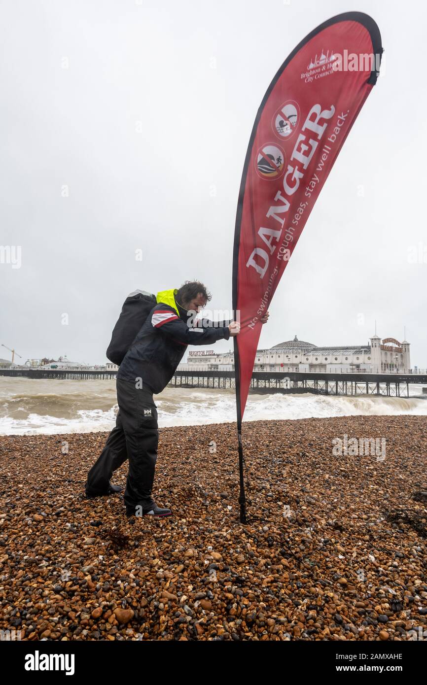 Brighton seafront manager Chris Ingalls secures Danger signs on Brighton Beach as Storm Brendan batters the south coast, at Brighton, East Sussex, UK Stock Photo