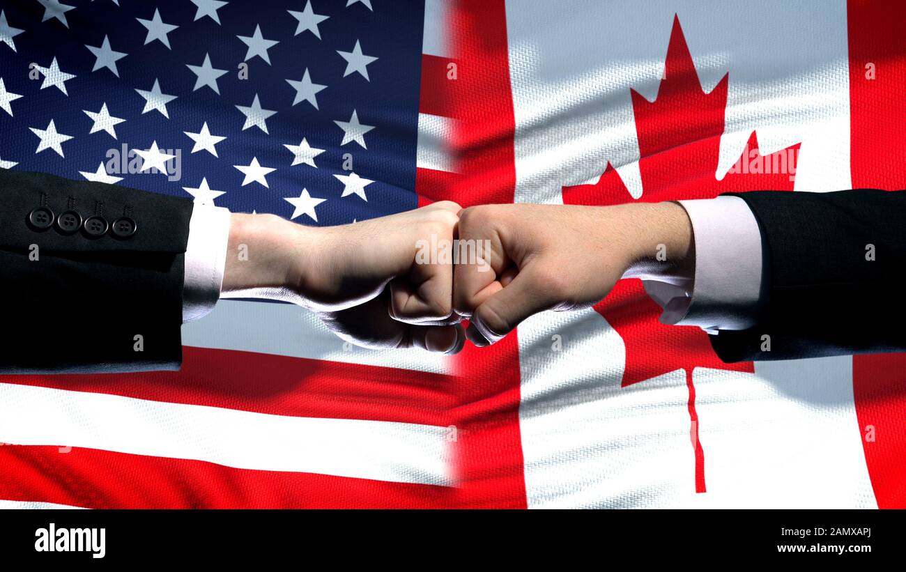 US vs Canada conflict, international relations crisis, fists on flag background Stock Photo