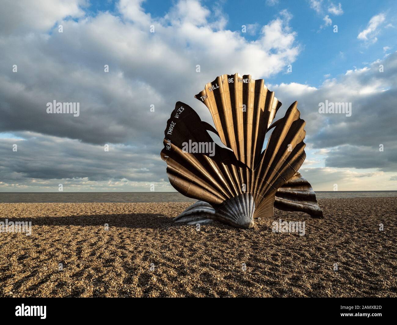 A view of the shell sculpture on Aldeburgh beach in bright sunlight with clouds in the sky. Stock Photo