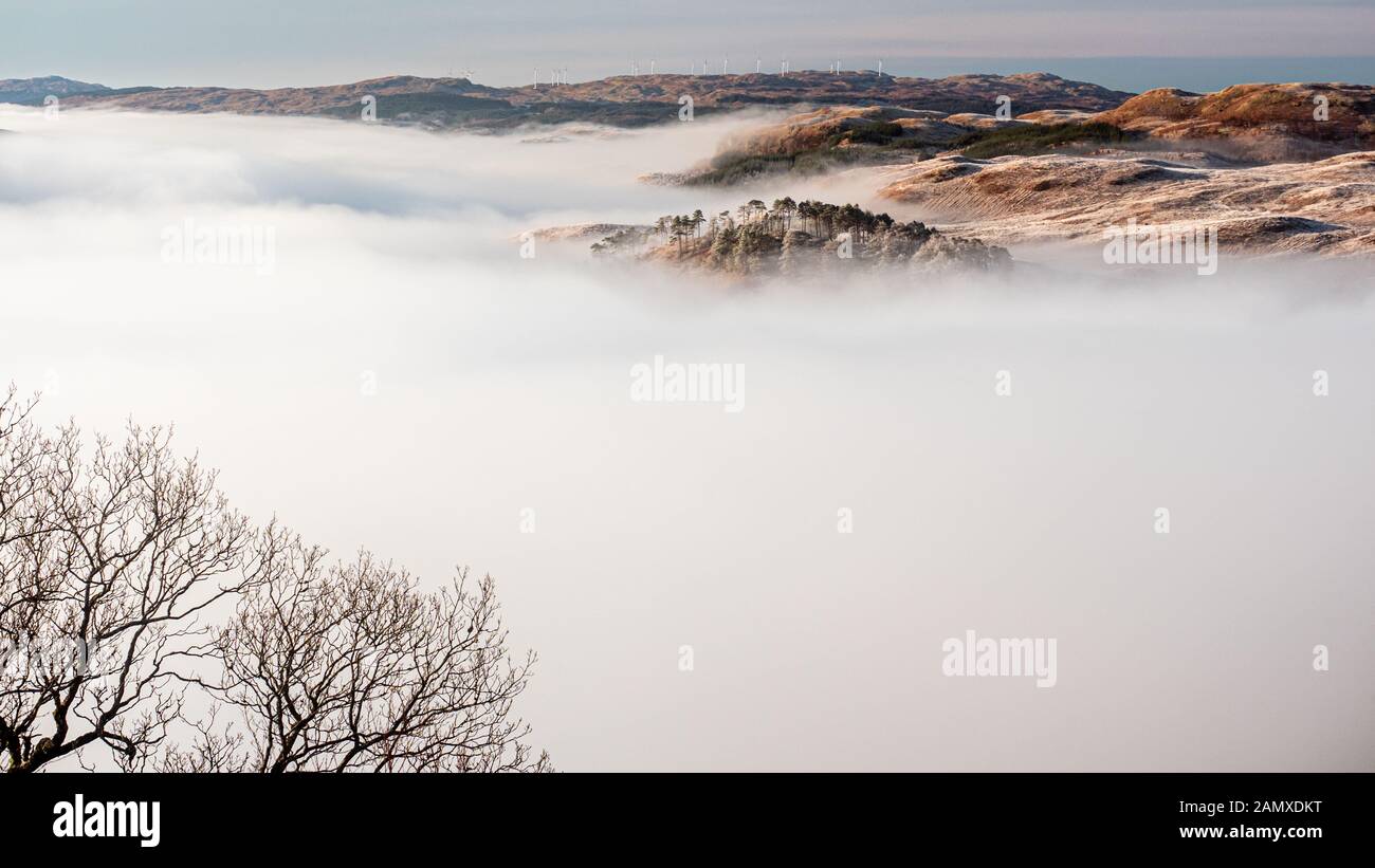 Panoramic view of beautiful cloud inversion, observed at sunrise from the slopes of Ben Cruchan as the hills above Loch Awe emerge from the sea of clo Stock Photo
