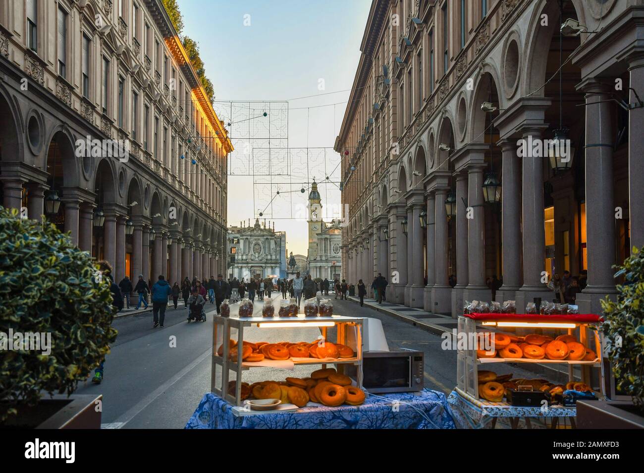 View of the historic centre of Turin with a stand selling donuts in Via Roma street and Piazza San Carlo square on Christmas Eve, Piedmont, Italy Stock Photo