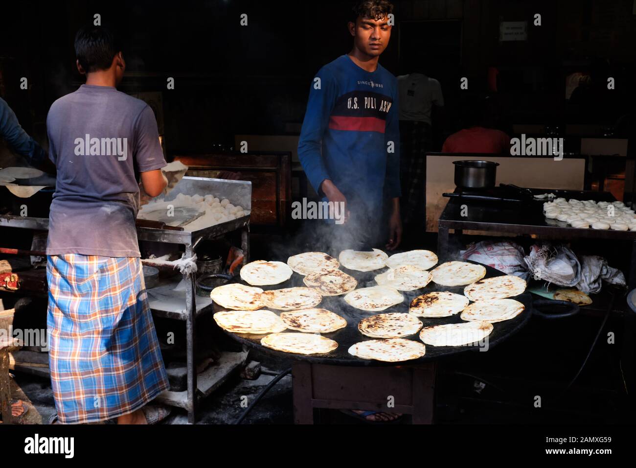 https://c8.alamy.com/comp/2AMXG59/at-a-cheap-roadside-restaurant-in-the-bhendi-bazar-area-of-mumbai-bombay-india-cooks-are-preparing-rotis-flatbreads-on-a-tawa-hot-plate-2AMXG59.jpg