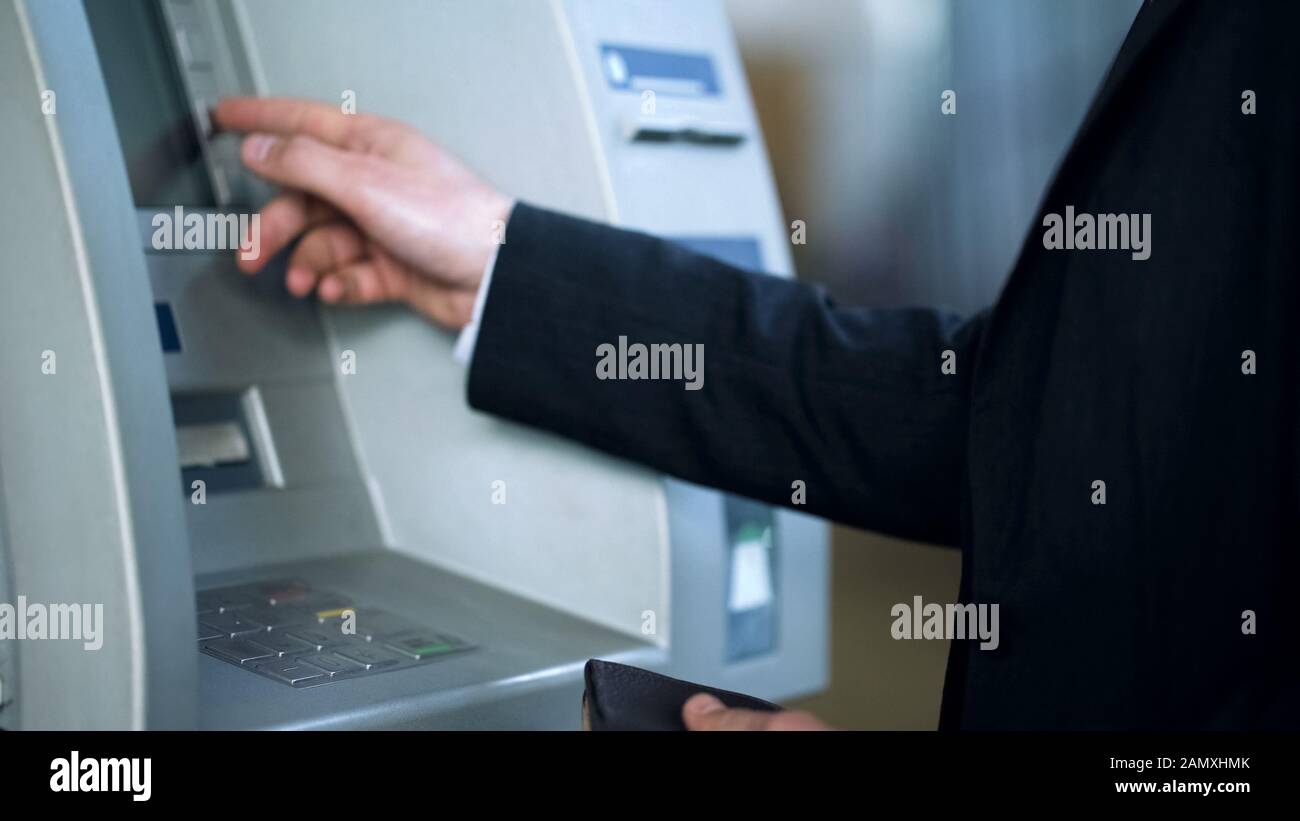 Male entering pin code on ATM keyboard to receive money, 24 hour service Stock Photo