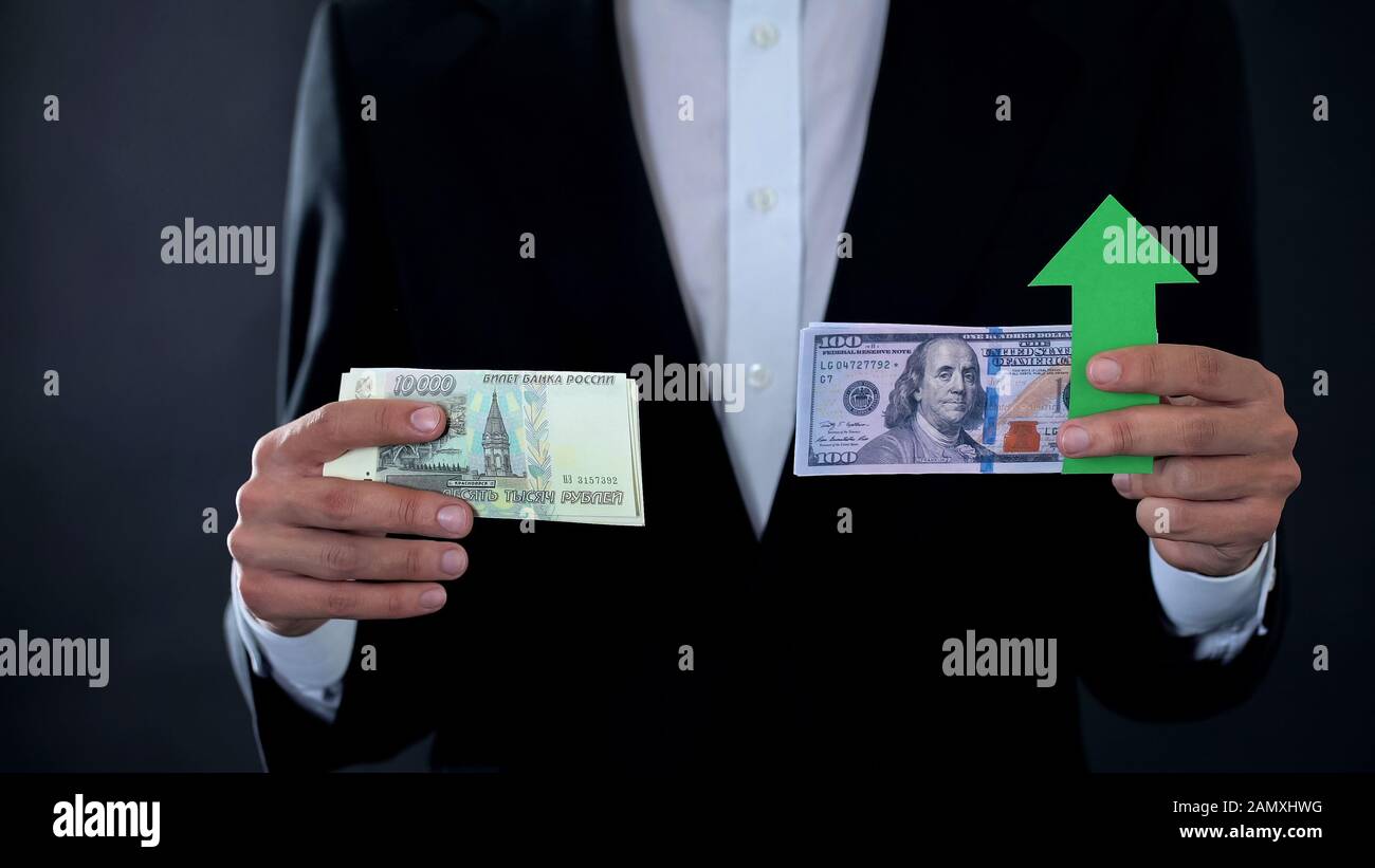 Man holding banknotes, dollar growing relative russian ruble, stock market Stock Photo