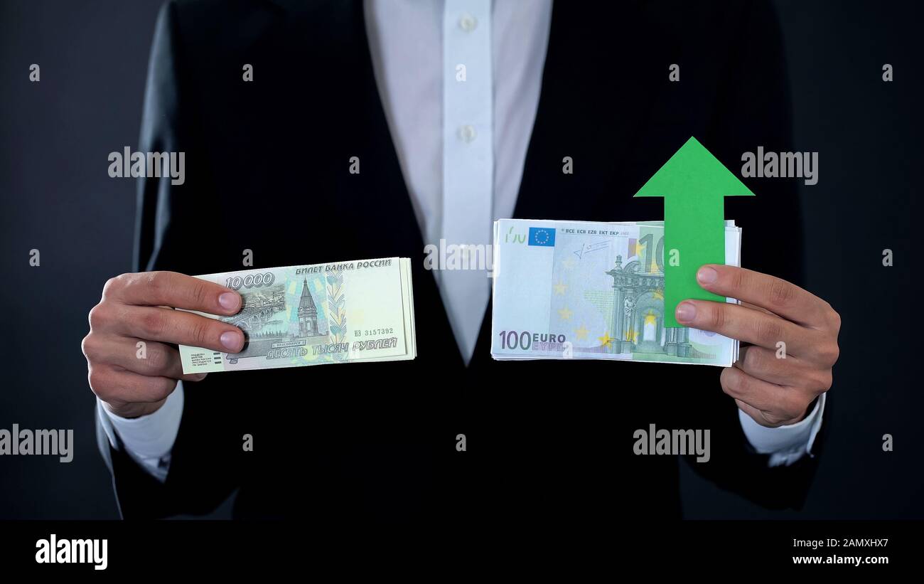 Man holding banknotes, euro growing relative russian ruble, financial forecast Stock Photo