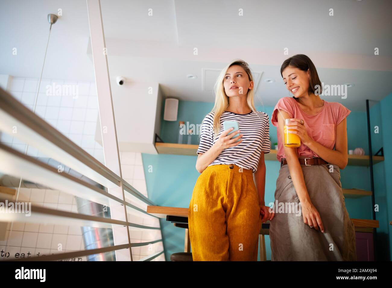 Beautiful young women friends using smart phone together and having fun ...