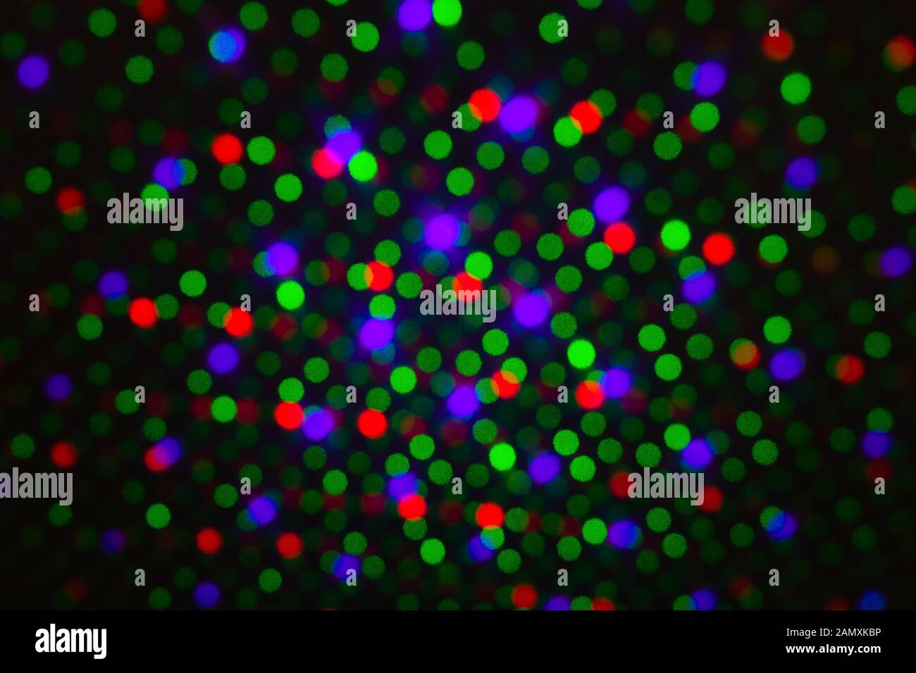 Abstract dot defocus background backdrop, rainbow colored green red violet round glitter on black background. Illumination blurry lights, abstract Stock Photo