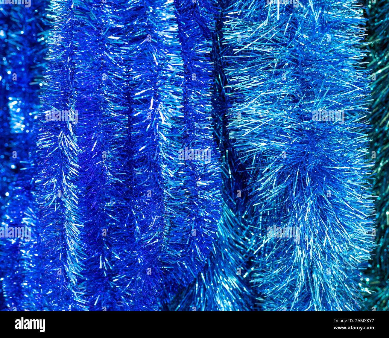 Fluffy foil blue tinsel, closeup background backdrop. Hanging