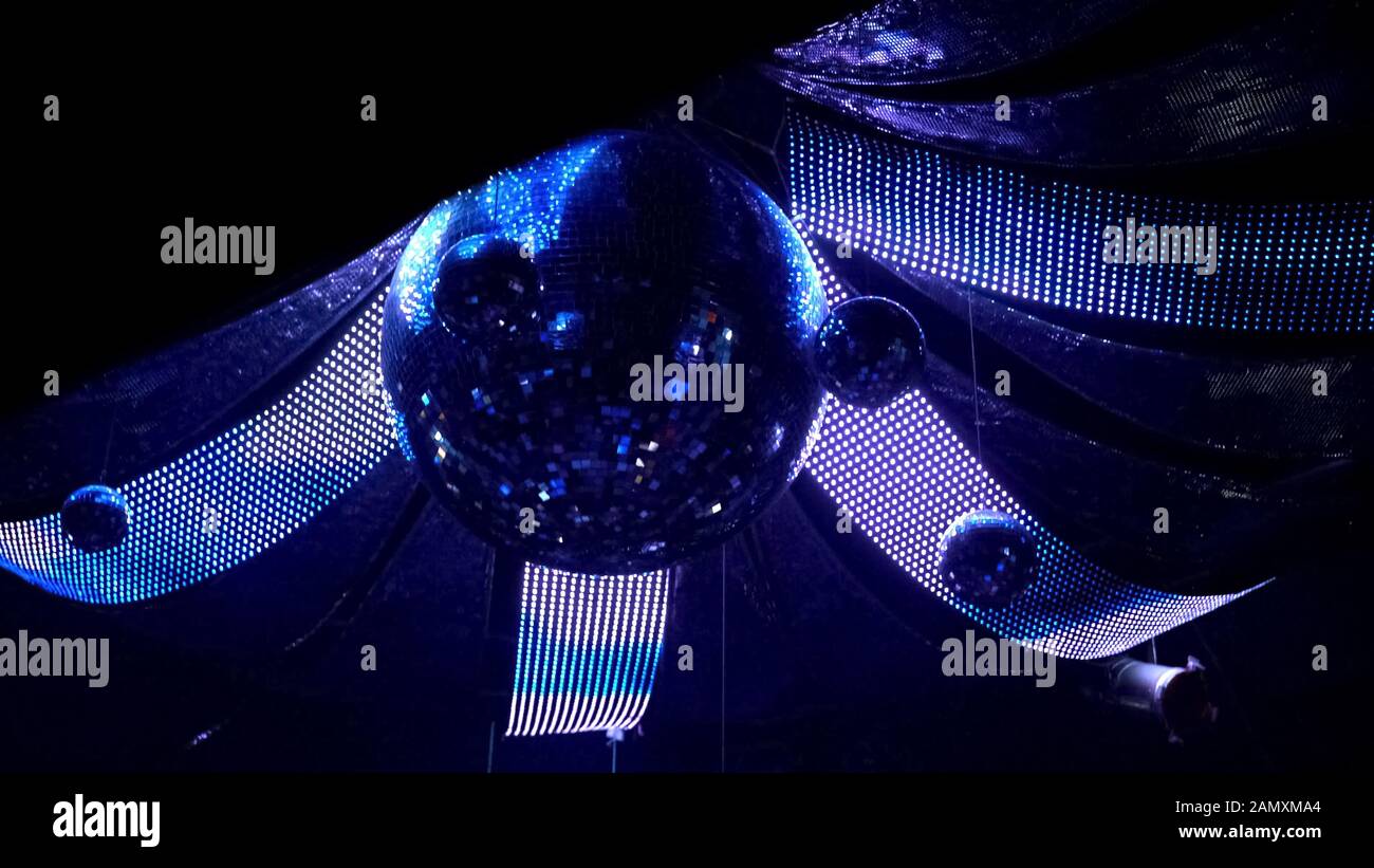 Rotating disco mirror ball with illuminated decoration, night club atmosphere Stock Photo