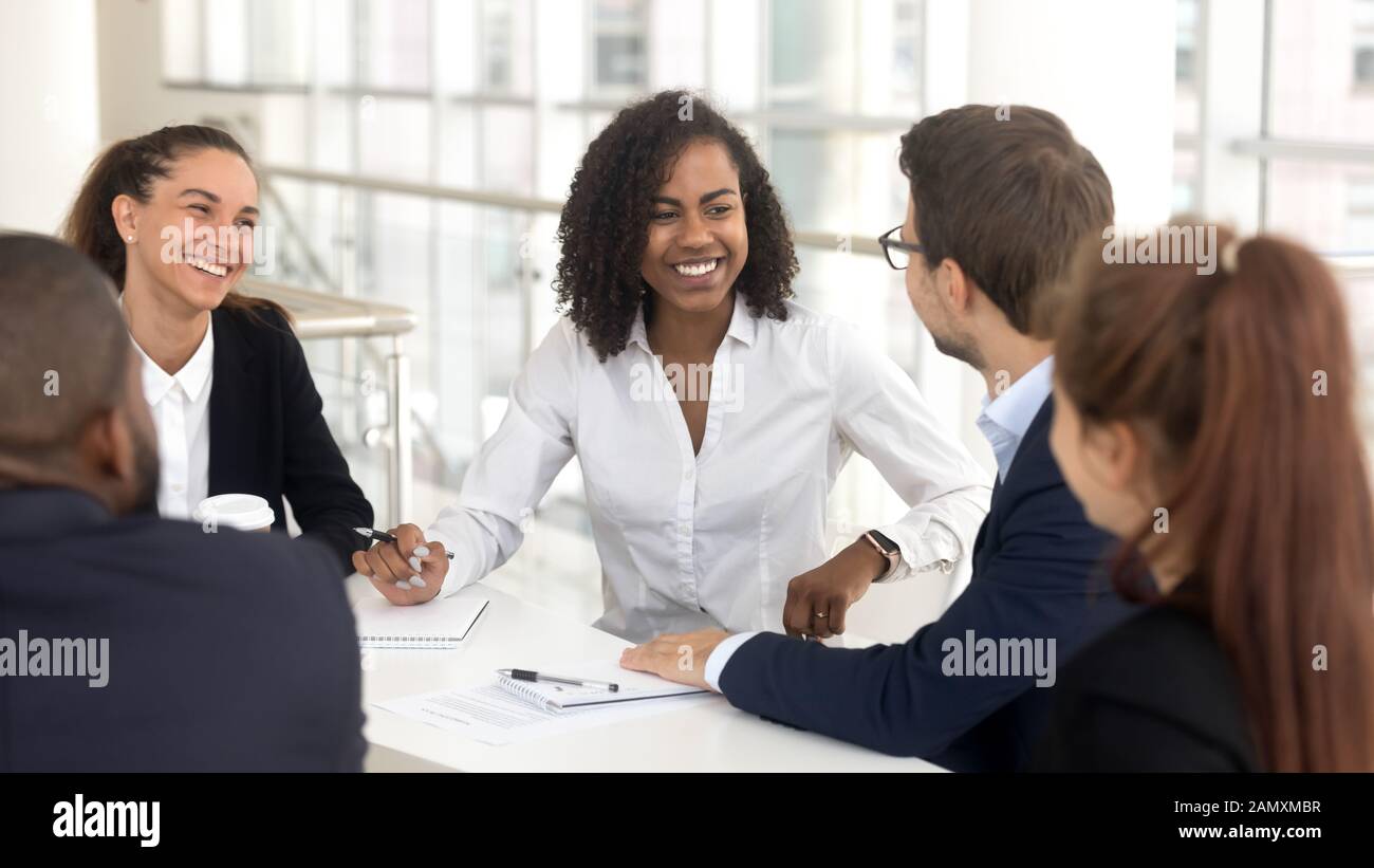 Smiling diverse employees discuss ideas brainstorming at office meeting ...
