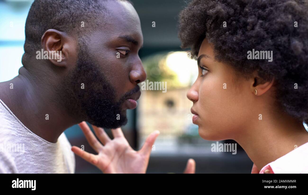 Boyfriend talking aggressively with girlfriend, relation difficulties, conflict Stock Photo