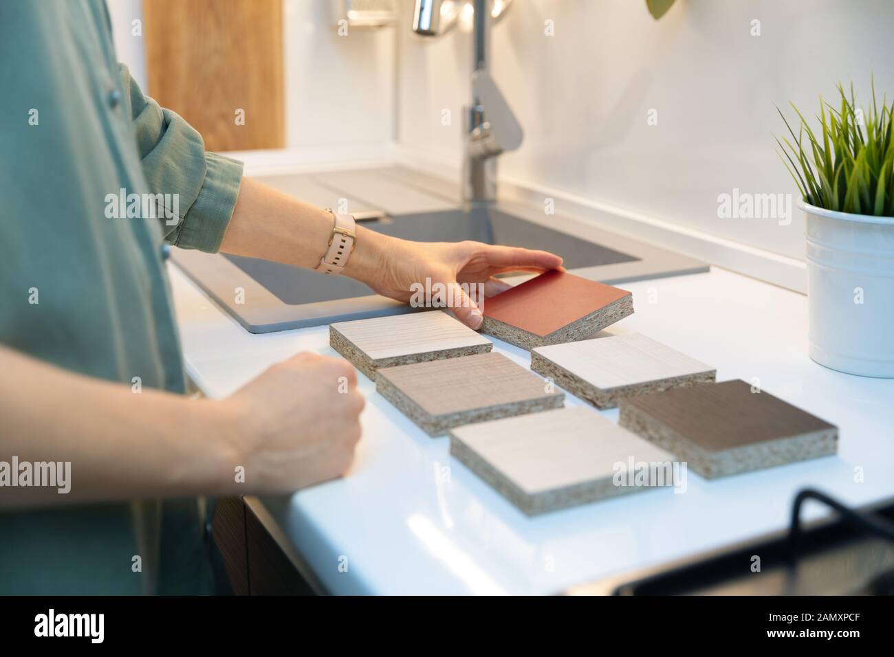 woman choosing kitchen countertop material texture from samples Stock Photo