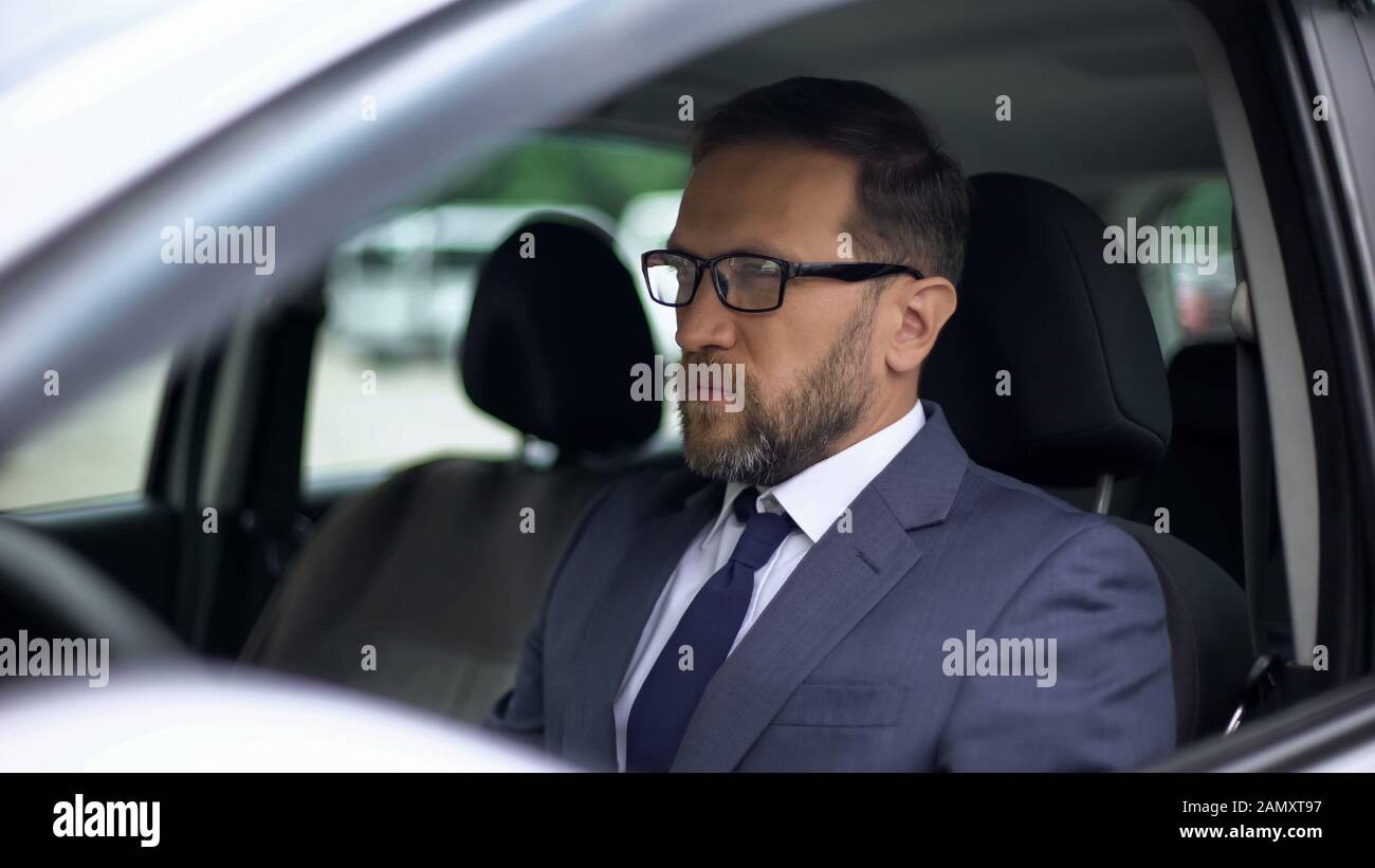 Serious businessman sitting in car, solitude before stressed work, day planning Stock Photo