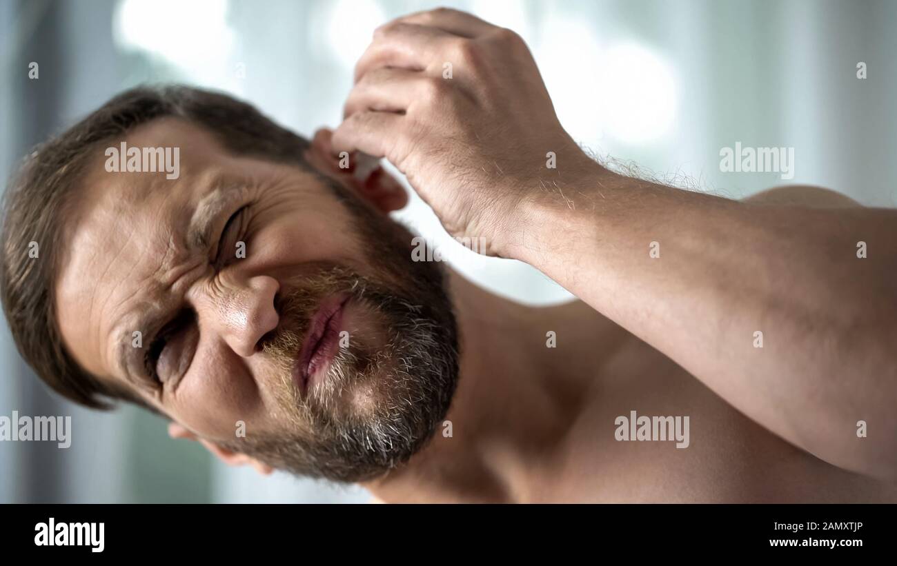 Unhealthy male dripping ear drops, bacterial infection self-treatment, otitis Stock Photo