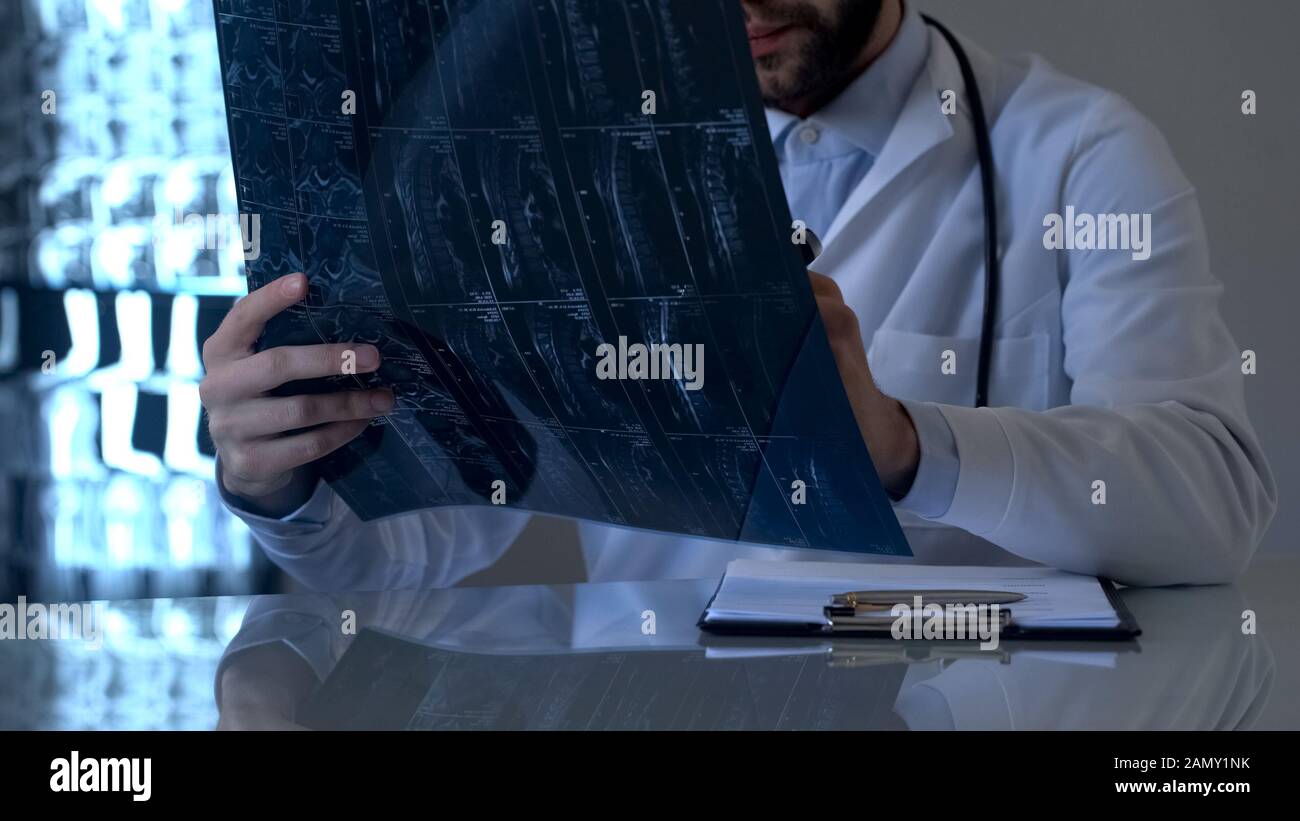 Spinal cord injury specialist examining patients xray in office