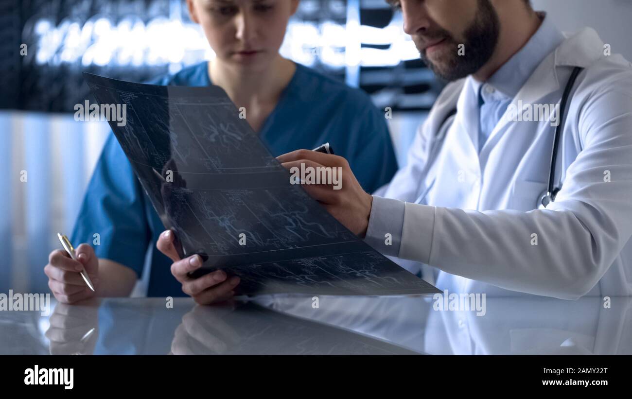 Neurosurgeon and nurse watching cerebral vessels x-ray before operation Stock Photo