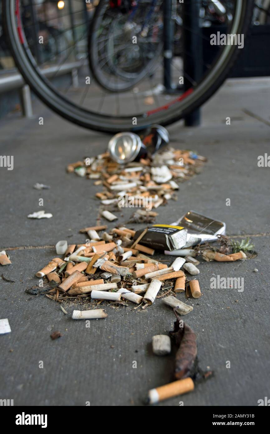 cigarette butts and other rubbish adjacent to parked bikes, in twickenham, middlesex, england Stock Photo