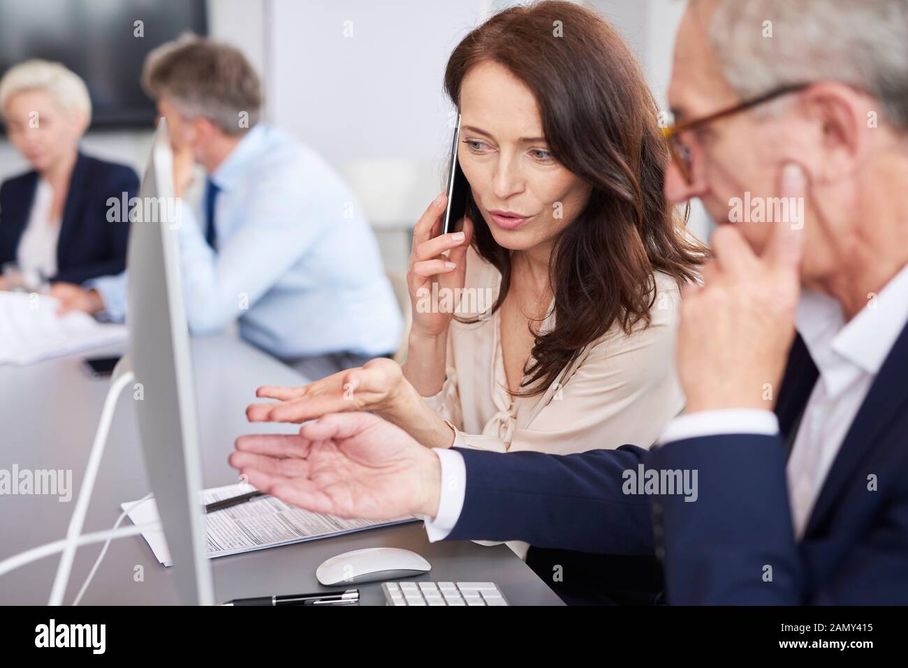 Busy woman analysing the charts and talking by mobile phone Stock Photo