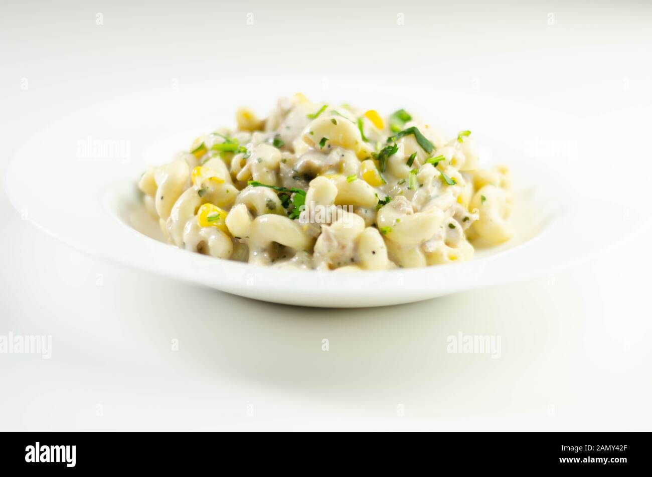 Cooked pasta with flaked tuna and sweetcorn in mayonnaise dressing, healthy salad Stock Photo