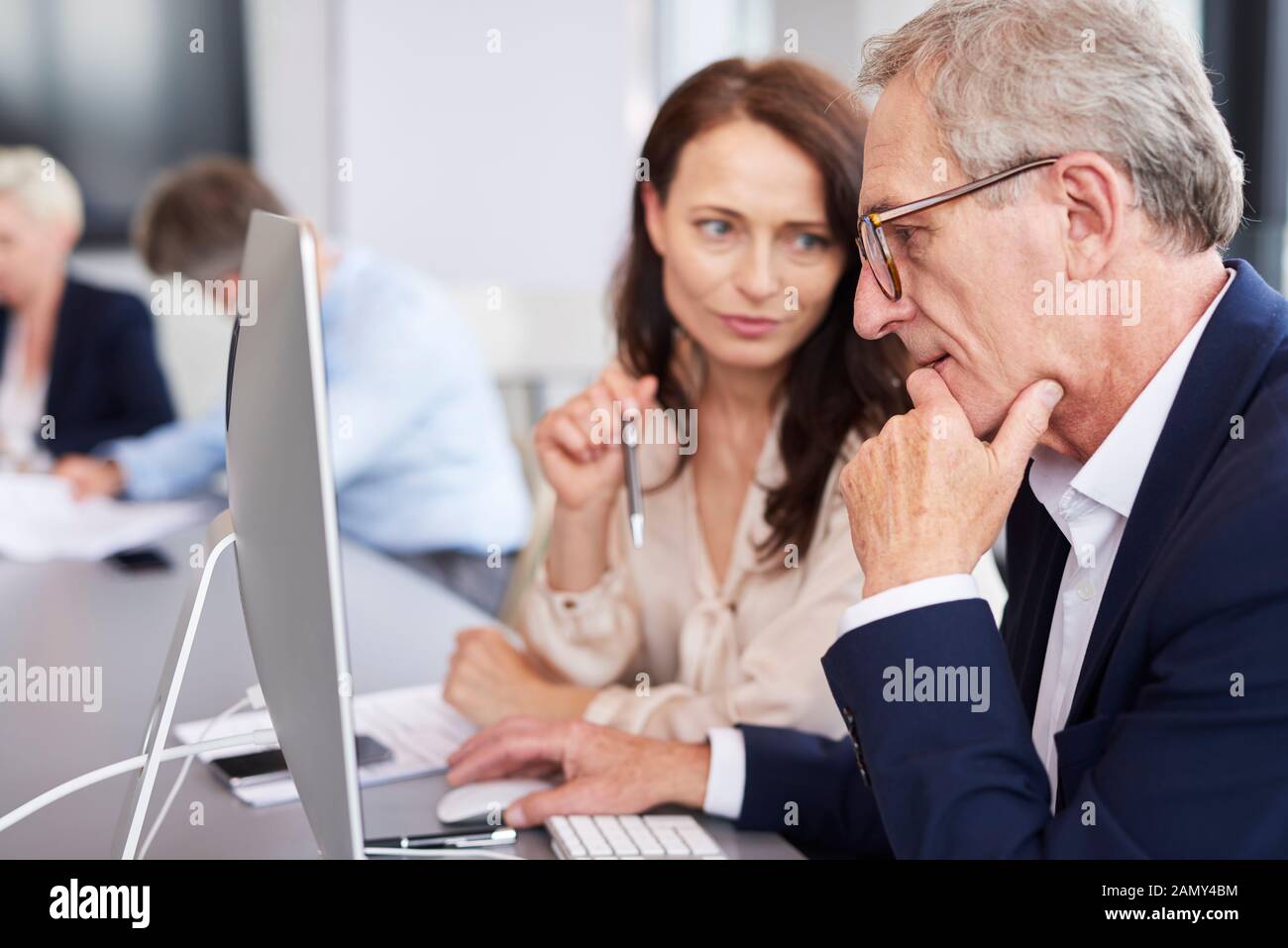 Busy businessman using a computer during business meeting Stock Photo