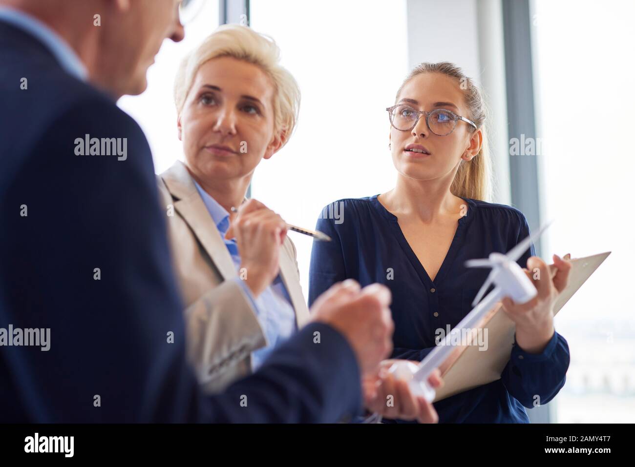 Busy office workers having a conversation in the office Stock Photo