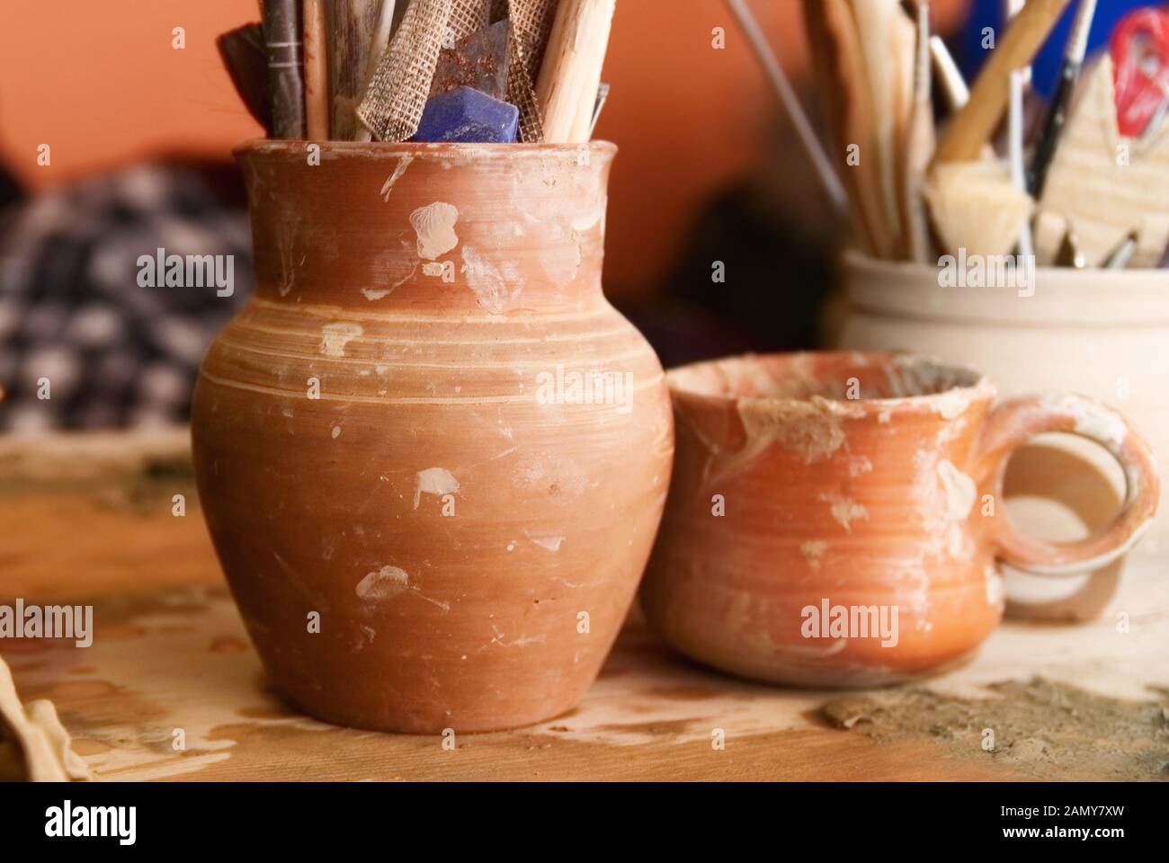 Handmade old clay pots with pencils and other stuff on the table Stock