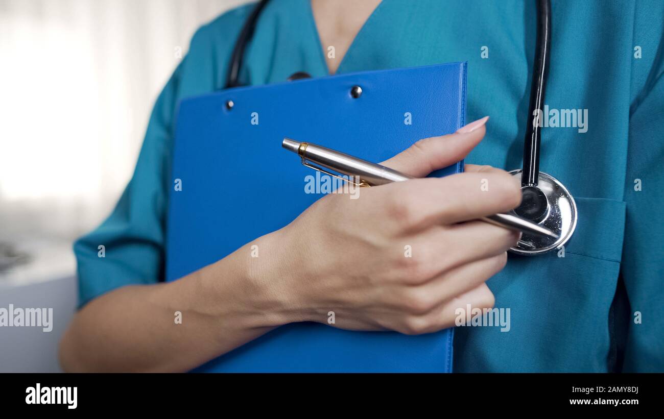Young nurse ready to writedown patient information into hospital form, anamnesis Stock Photo